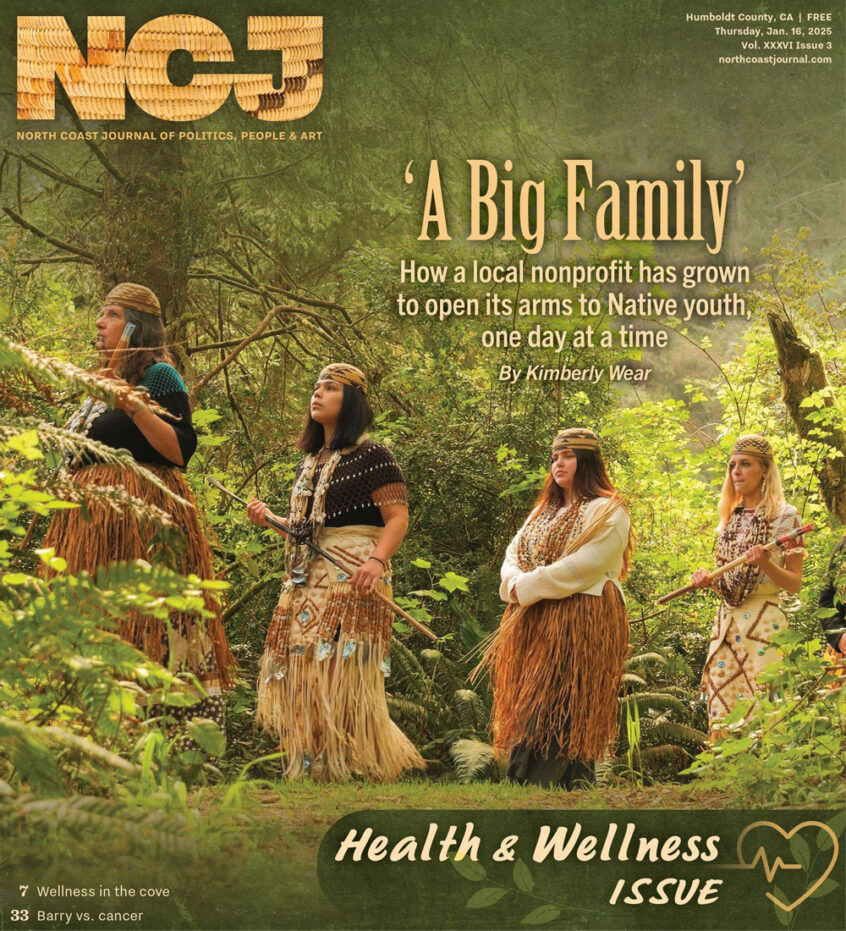 A newspaper cover featuring 4 women in traditional dress walking through the forest