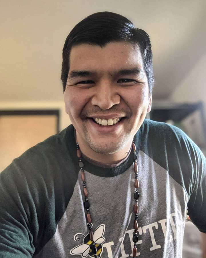 A person leans in toward the camera and smiles