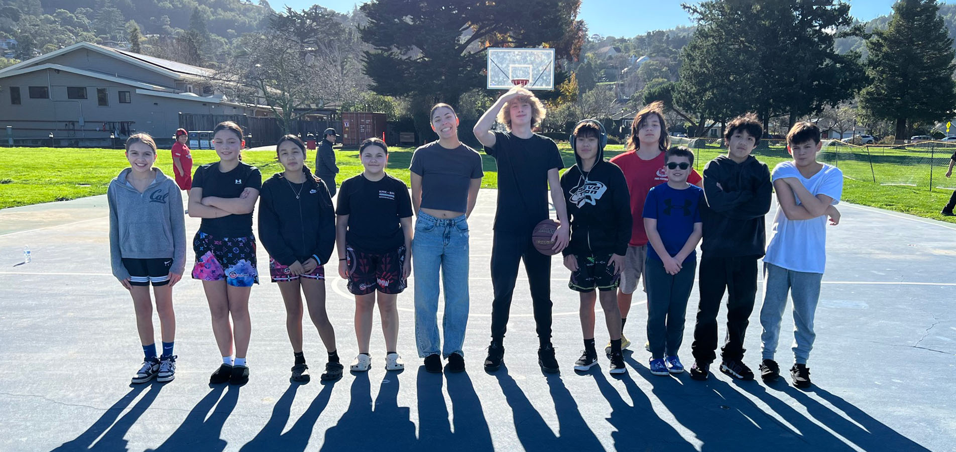 A group of young adults stand on a basketball court