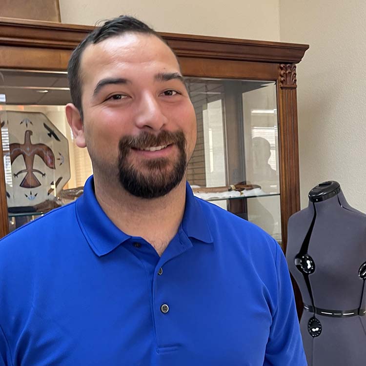 A smiling person stands in a decorated room