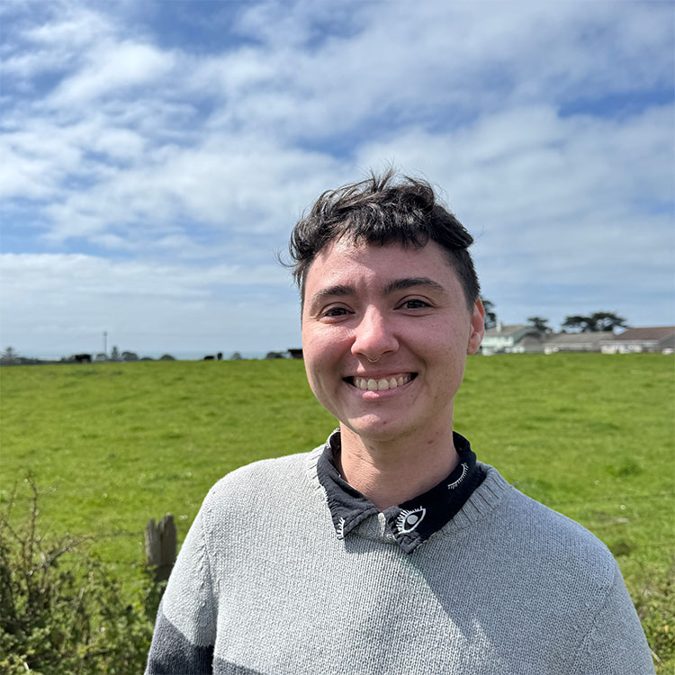 A headshot of a smiling person in a field