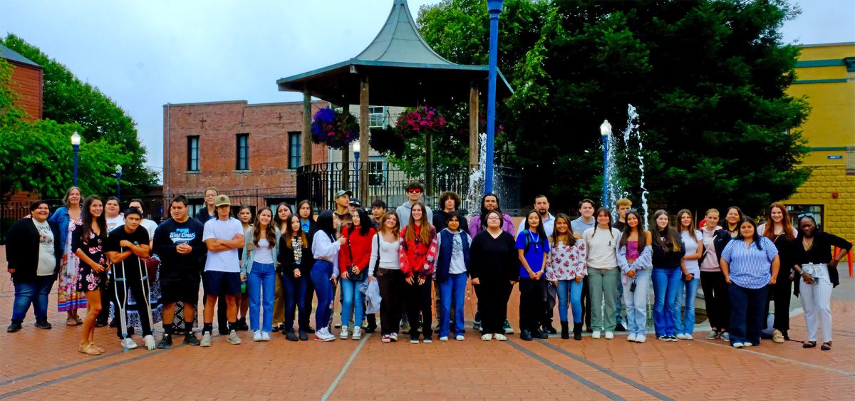 A group of people stand in a courtyard and pose for the camera
