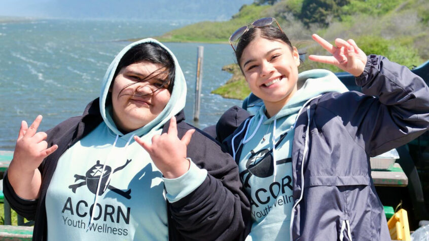 Two smiling people pose for a camera