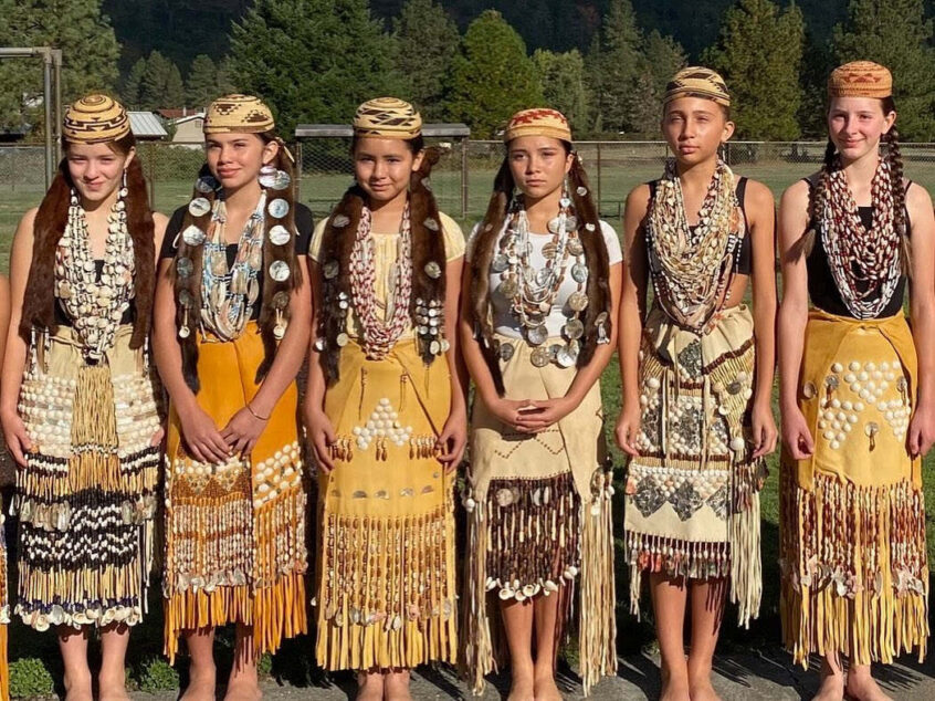 Several young women stand together in traditional dress