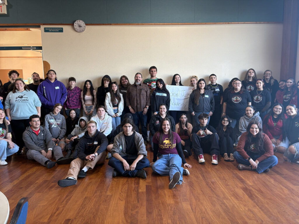 A group of young adults pose together in a gymnasium