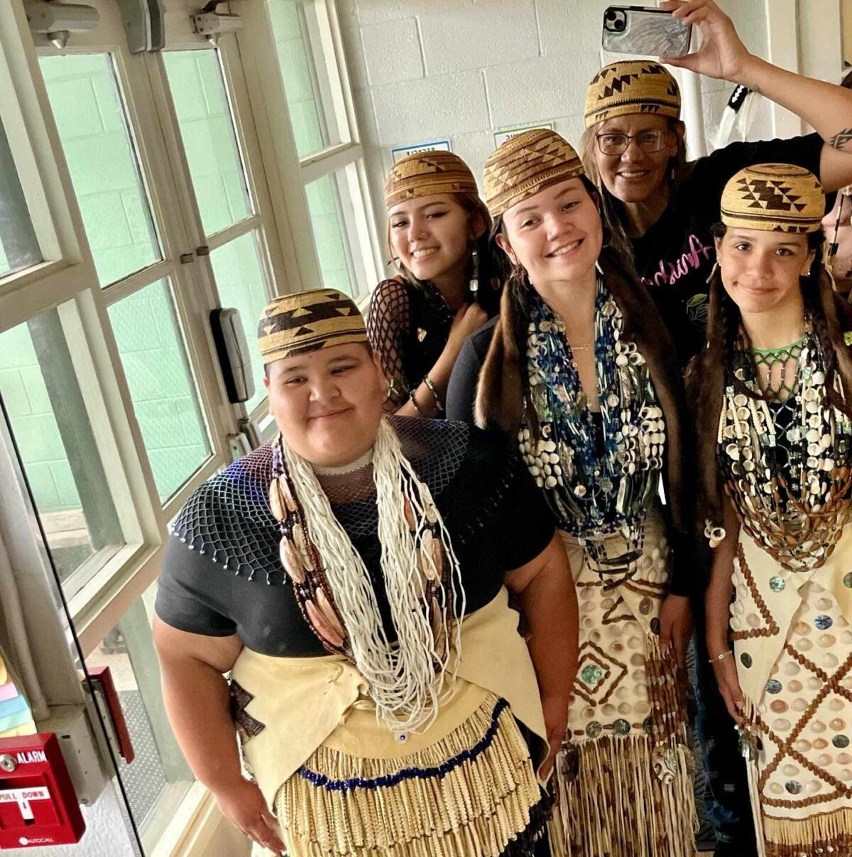 A group of Native American women in traditional dress pose together