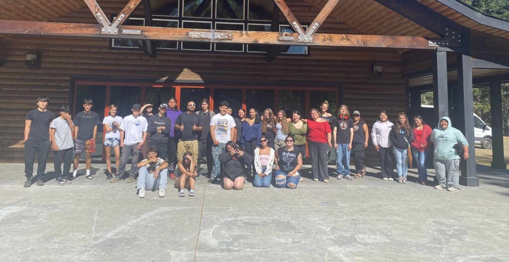 A group of people pose together at a camp