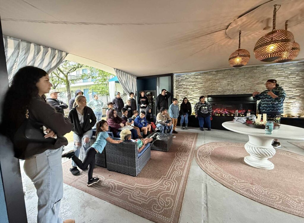 A group of people watch a person give a presentation