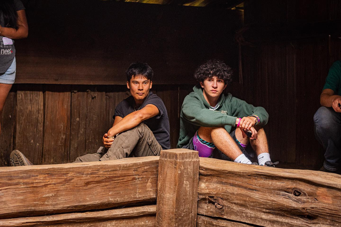 Two young adults sit in a traditional lodge