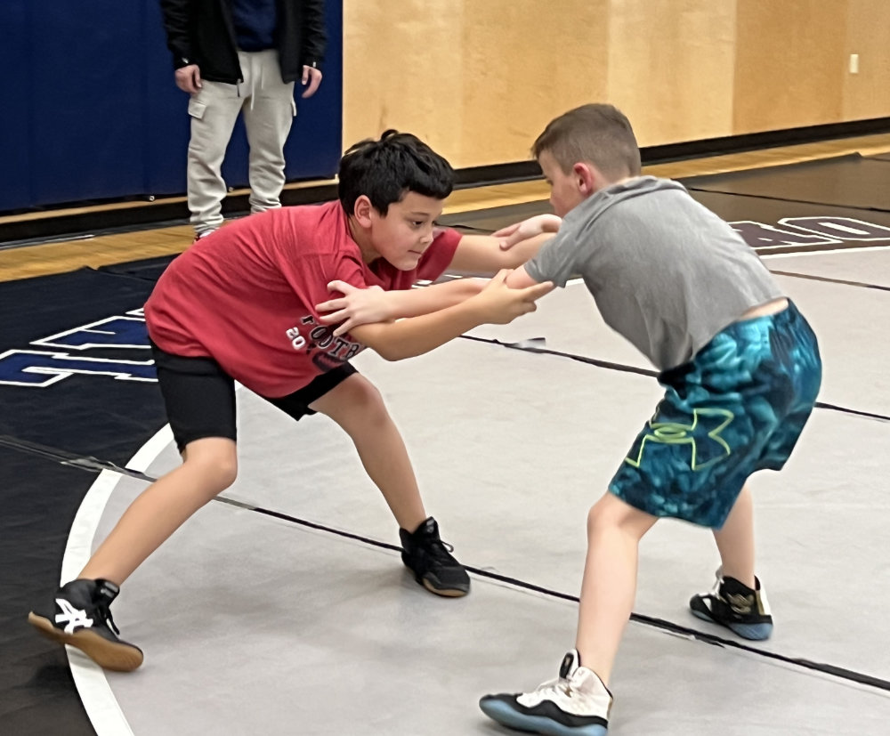 Two youth wrestle in a gym