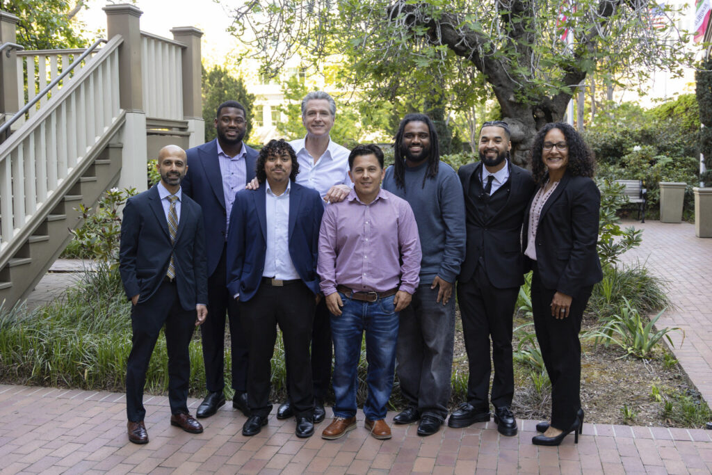 A group of professionally-dressed people stand together and pose for the camera