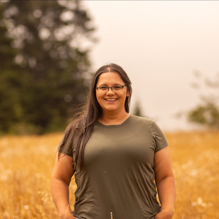 A headshot of a smiling person in a field